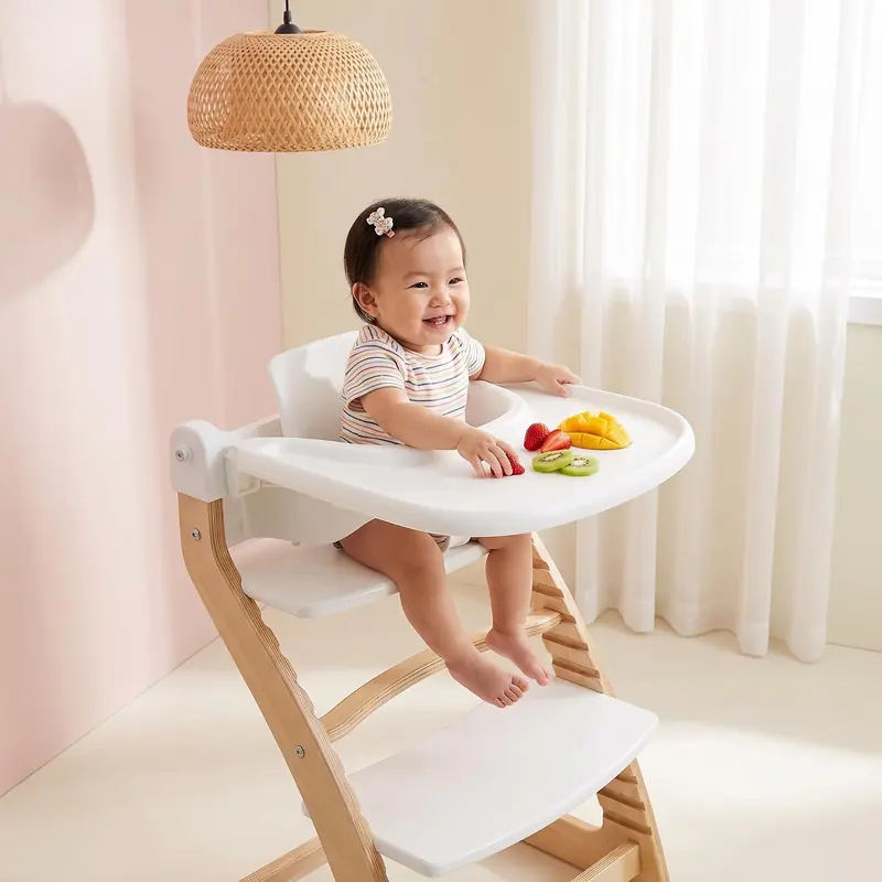 Smiling baby in the Fornel chair with the Baby Set tray